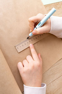 Cropped hands of woman writing on paper