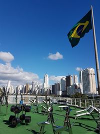 Scenic view of flag in city against sky