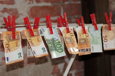 Close-up of paper currencies hanging on clothesline