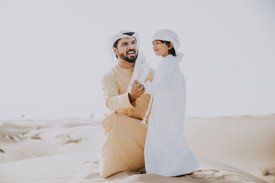 Young couple kissing against white background