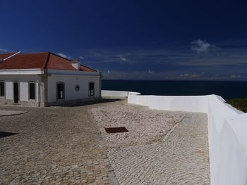 House on beach by sea against sky