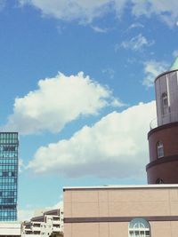 Low angle view of buildings against cloudy sky