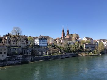 Buildings in city against clear blue sky