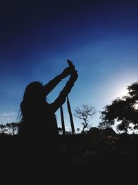 Low angle view of silhouette trees against sky