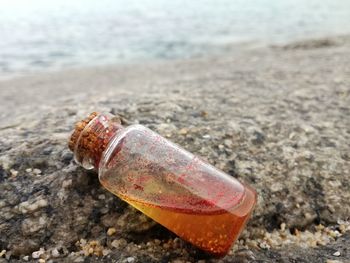 Close-up of bottle on beach