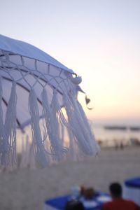 Close-up of sea shore against sky during sunset