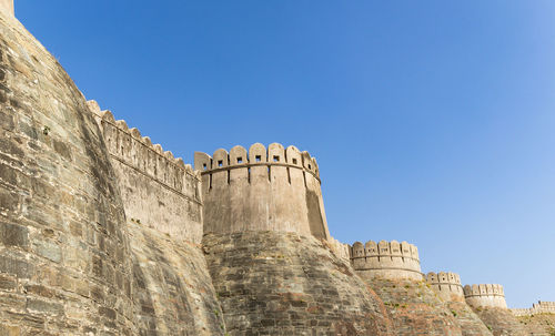 Ancient fort exterior wall ruins with bright blue sky at morning