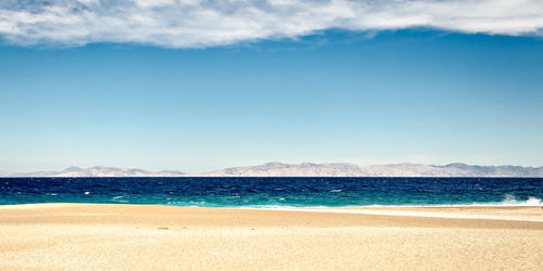 Scenic view of beach against blue sky