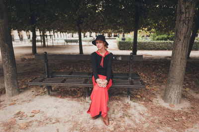 Full length of woman standing on tree trunk