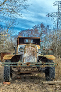 Abandoned truck on field against sky