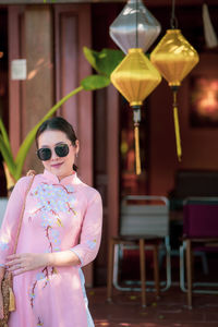 Portrait of woman wearing sunglasses standing outdoors