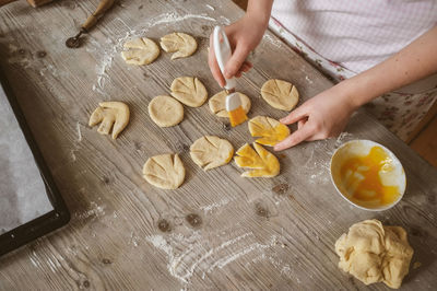 Cropped image of hand making cookies on table