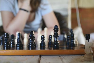 Midsection of woman playing chess on table