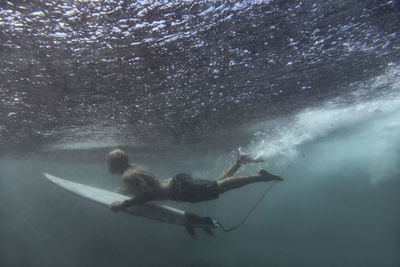 Surfer on surfboard, underwater shot