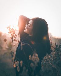 Midsection of woman with arms raised against sky