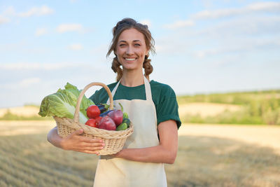 Portrait of smiling young woman holding basket