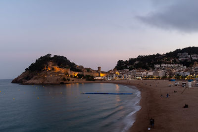 The sun sets over the golden sands of tossa de mar, spain, casting a warm glow over the beach