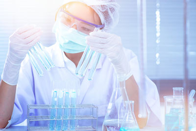 Scientist examining blue chemical in laboratory