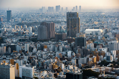 Aerial view of buildings in city against sky