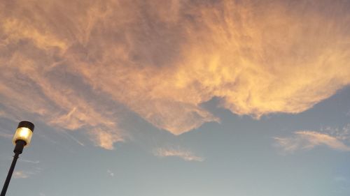 Low angle view of illuminated street light against sky