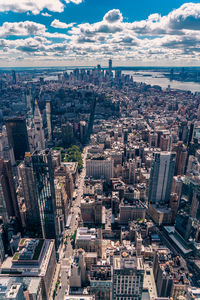 Aerial view of illuminated skyscraper buildings in city at day at high angle