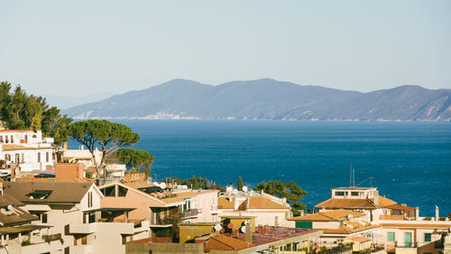 High angle view of houses by sea against sky