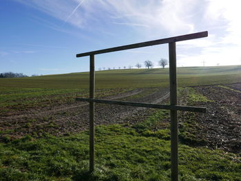 View of field against cloudy sky