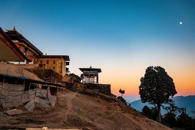 Buildings against clear sky at sunset