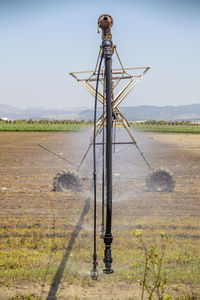 Windmill on field against clear sky