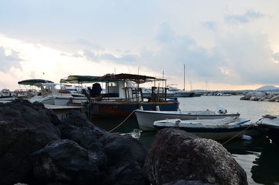 Boats in sea against cloudy sky