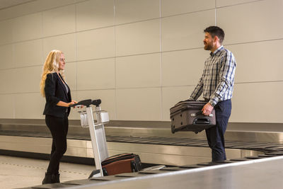 Couple taking luggage from conveyor belt