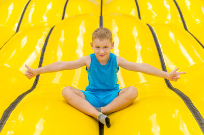 Happy girl on yellow slide at playground