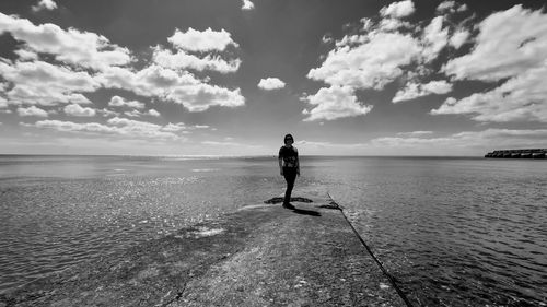 Man standing in sea against sky