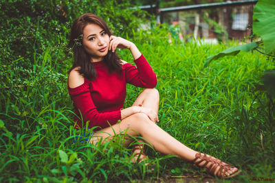 Portrait of smiling young woman sitting on grass