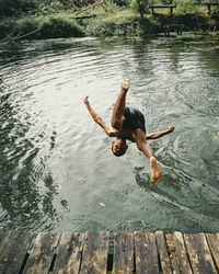 High angle view of man jumping in lake