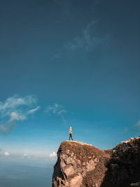 Full length of man standing at cliff against sky