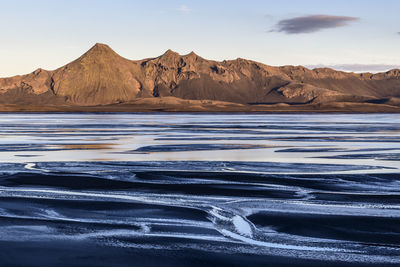 Scenic view of sea and mountains against sky