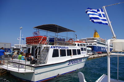 Boats moored at harbor against clear blue sky