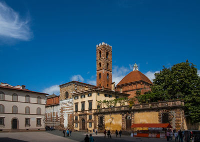 Buildings in city against blue sky