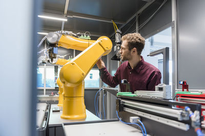 Businessman checking industrial robot in high tech company