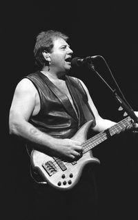 Man playing guitar against black background