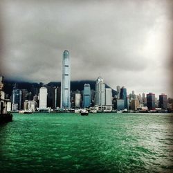 River in city against cloudy sky