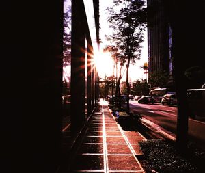 Cars on illuminated city against sky during sunset