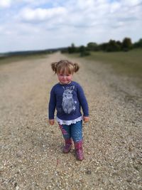 Boy standing on field against sky