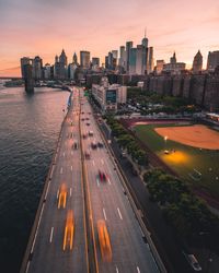 High angle view of road amidst buildings in city during sunset