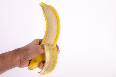 Cropped image of hand holding fruit against white background