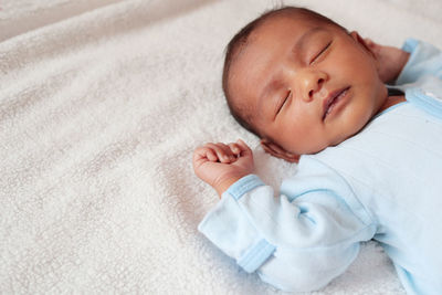 High angle view of baby boy sleeping on bed