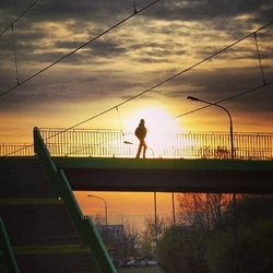 Bridge over river against cloudy sky