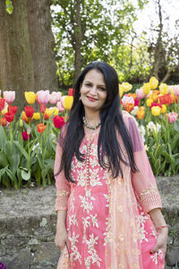 A beautiful indian woman with black hair in a national indian pink sari dress