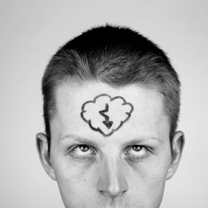 Close-up of man with arrow symbol on forehead against white background